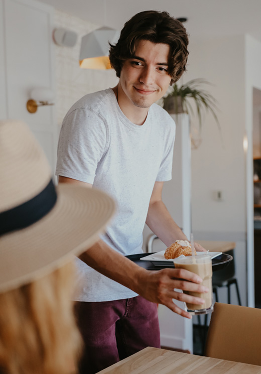 Jeune serveur qui apporte une commande